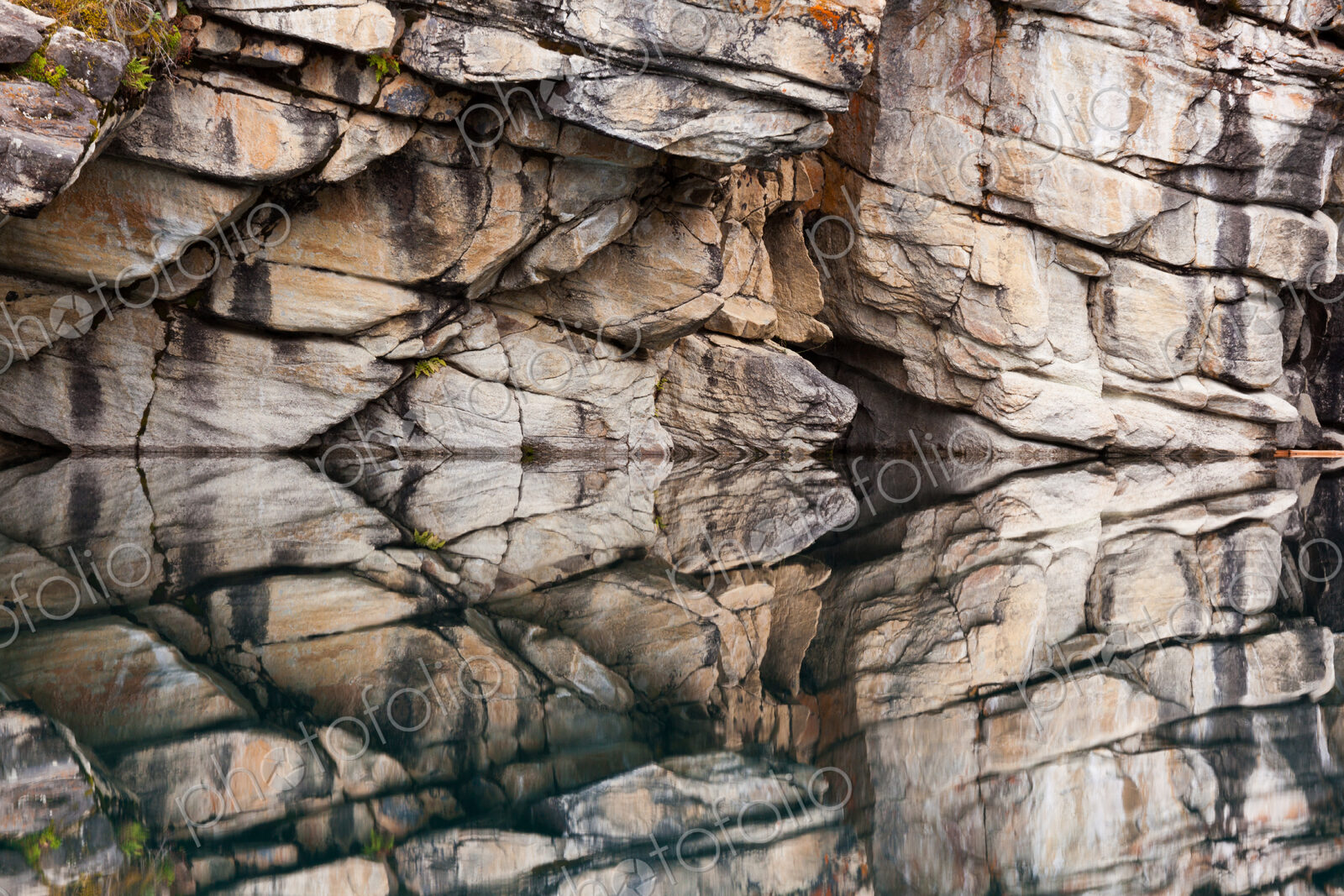 Rocky cliffs perfectly reflected in the calm waters of Horseshoe Lake, Jasper National…