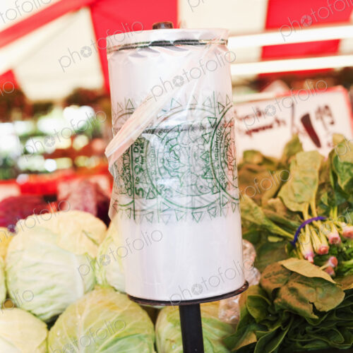 Roll of plastic bags on vegetable stall in market.