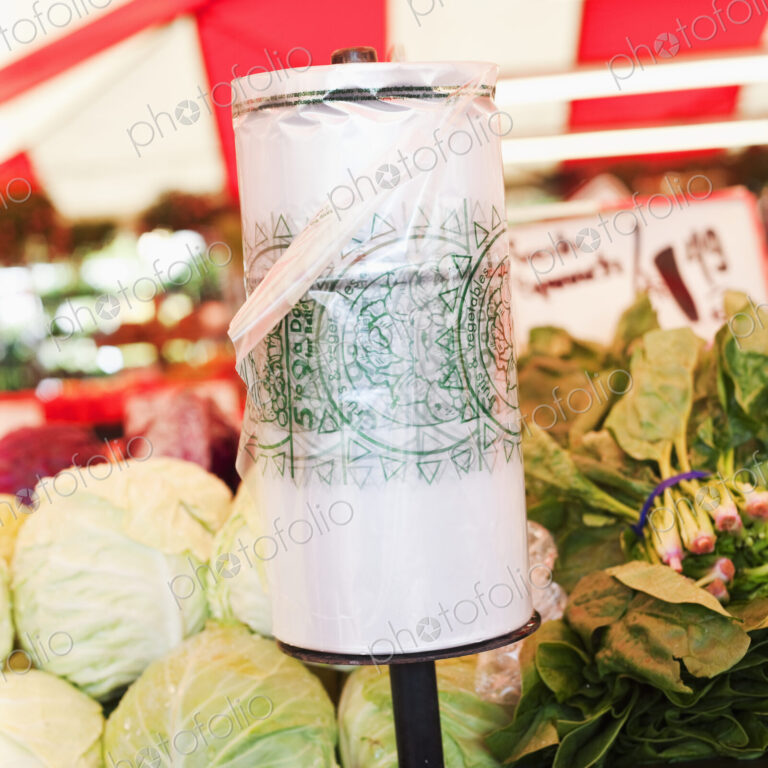 Roll of plastic bags on vegetable stall in market.