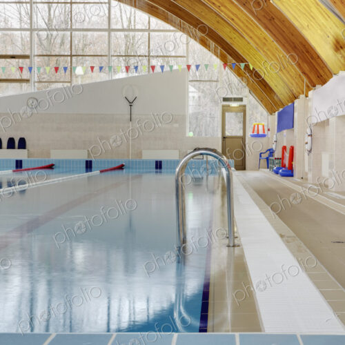 Roof beams under a curved roof over an indoor swimming pool.