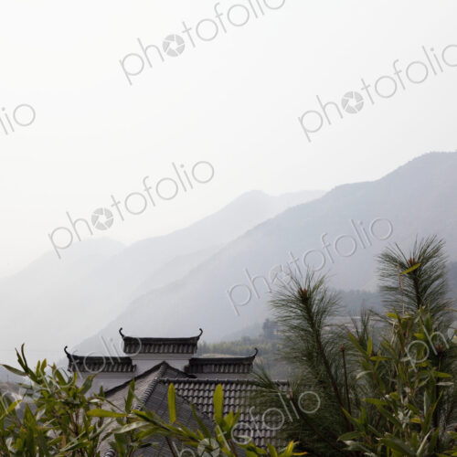 Rooftop among trees with mountains in background, Beijing, China Rooftop among trees with mountains in background, Beijing, China