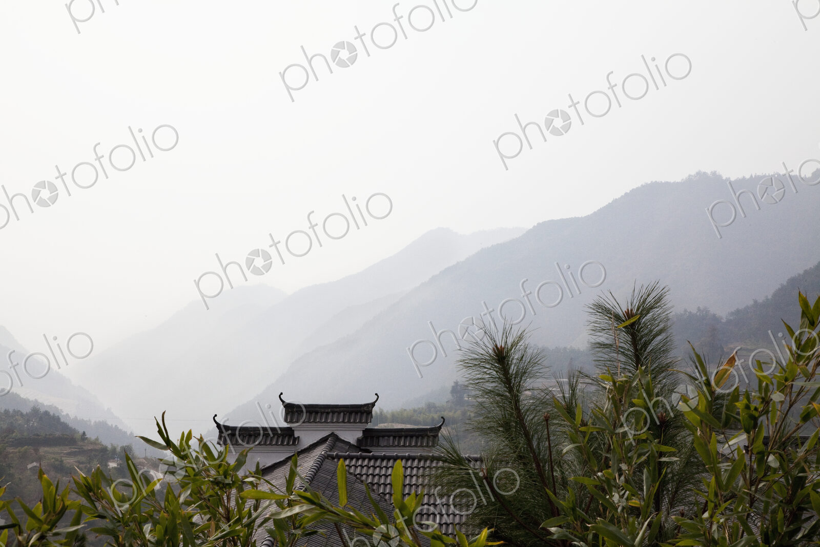 Rooftop among trees with mountains in background, Beijing, China