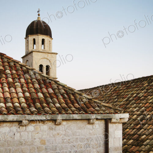 Rooftops and a bell tower at sunset in the old city of Dubrovnik Rooftops and a bell tower at sunset in the old city of Dubrovnik