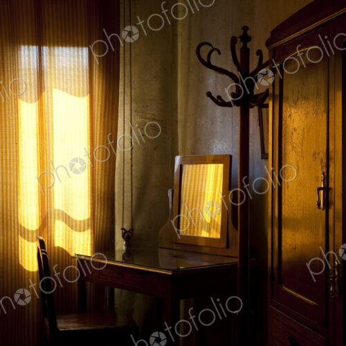 Room interior with vintage wooden dressing table, drawn curtains and sunlight Room interior with vintage wooden dressing table, drawn curtains and sunlight
