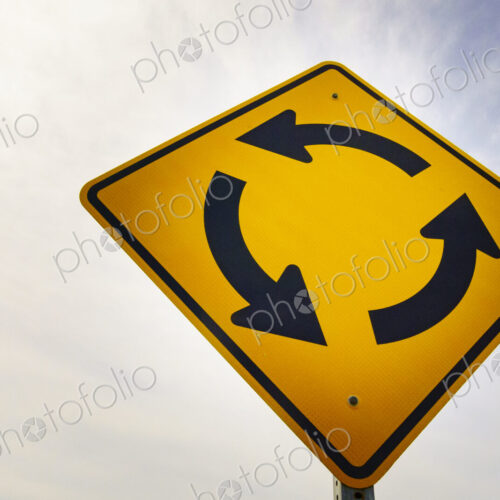 Round-a-bout traffic sign, yellow directional arrows, anticlockwise direction of flow,…