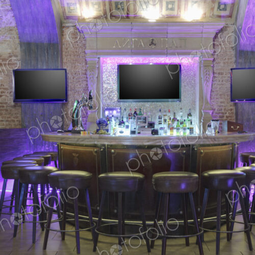 Round bar stand against three TV screens on brick wall. Round bar stand against three TV screens on brick wall.