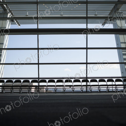 Row of chairs silhouetted against a window in a conference centre.