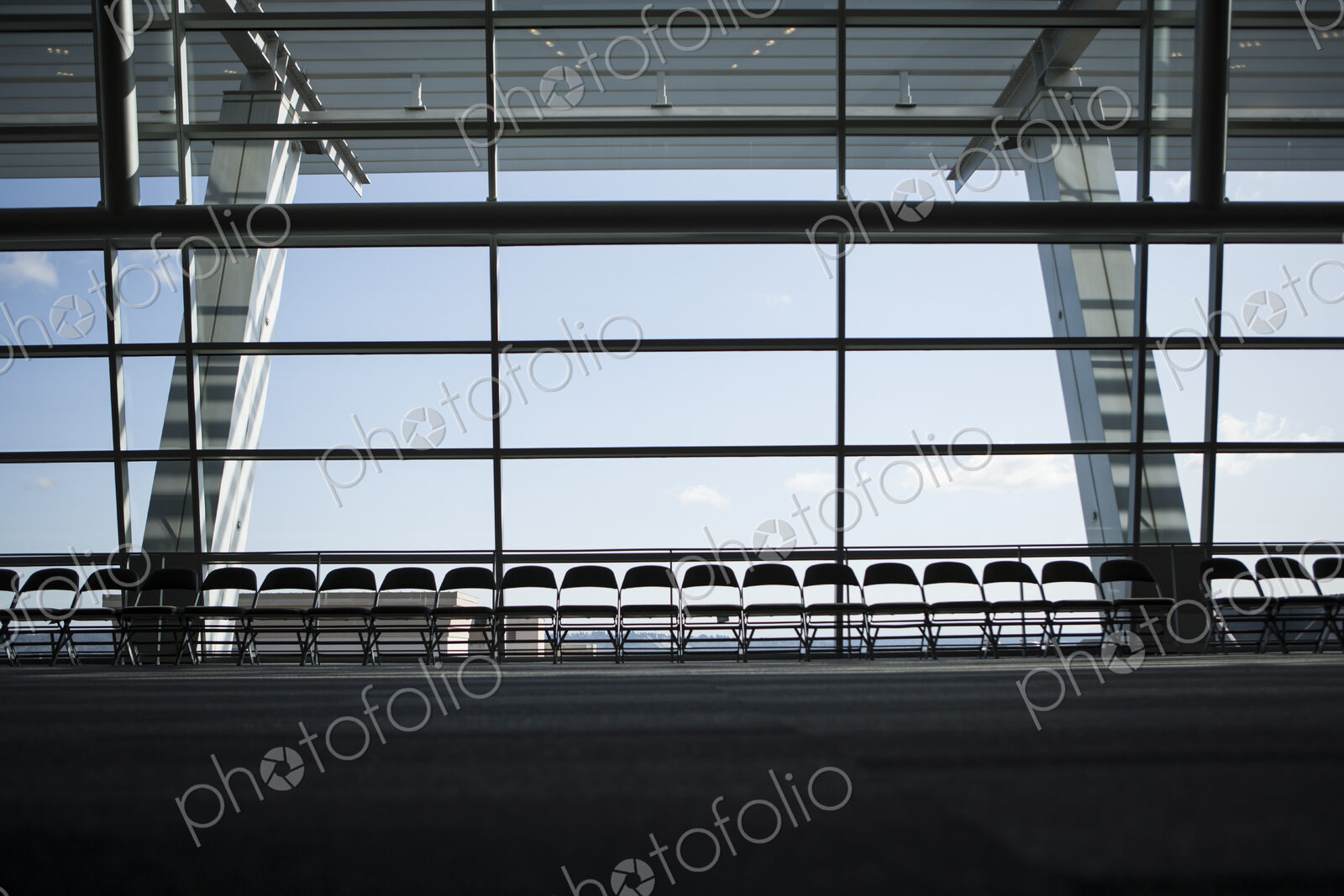 Row of chairs silhouetted against a window in a conference centre.