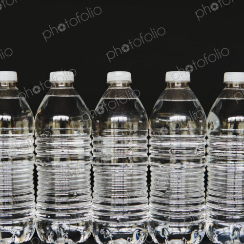 Row of clear, plastic water bottles filled with filtered water