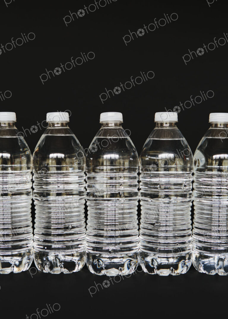 Row of clear, plastic water bottles filled with filtered water