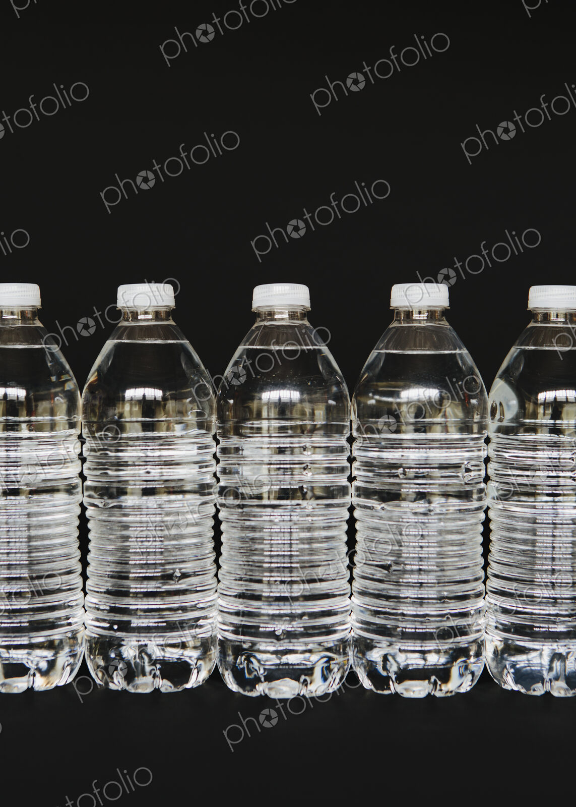 Row of clear, plastic water bottles filled with filtered water