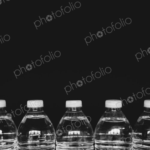 Row of clear, plastic water bottles filled with filtered water