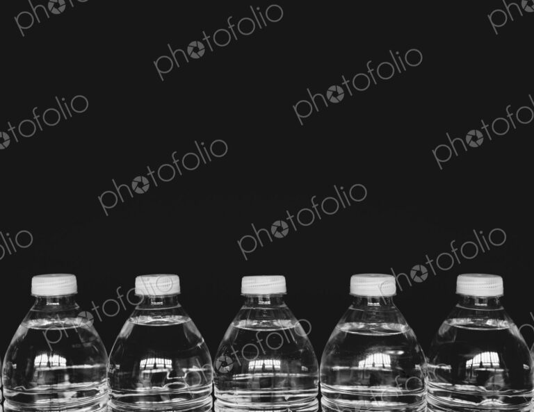 Row of clear, plastic water bottles filled with filtered water