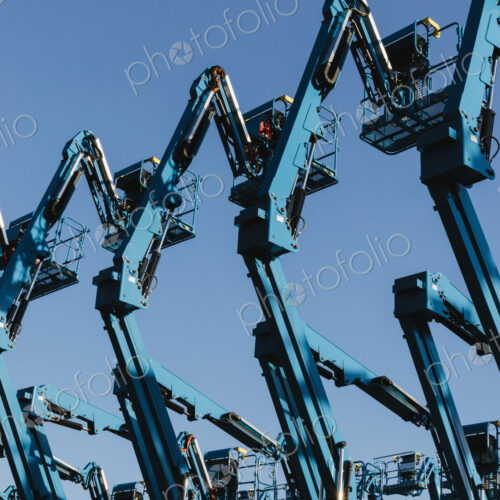 Row of hydraulic mobile cherry picker platforms at outdoor storage facility