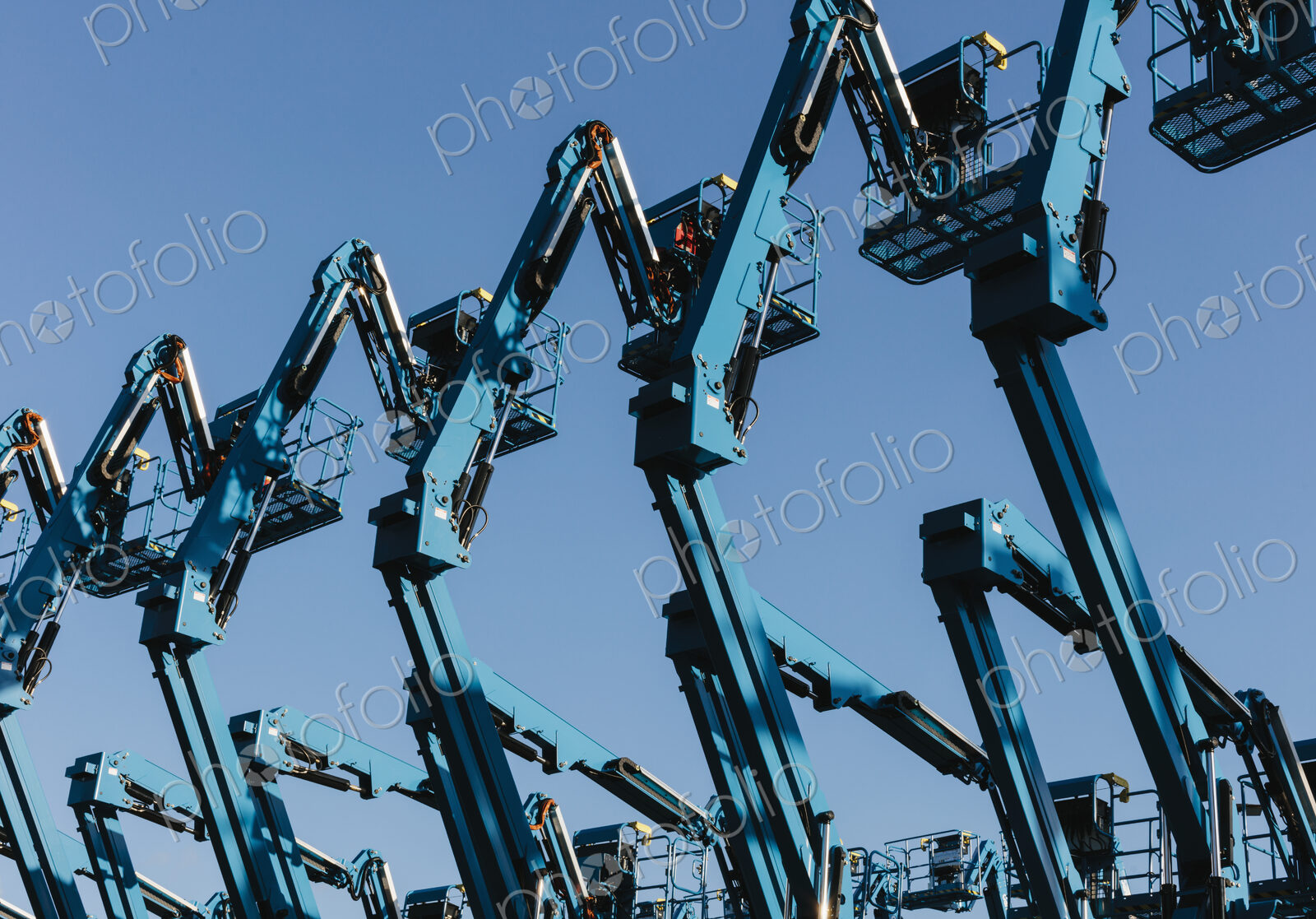 Row of hydraulic mobile cherry picker platforms at outdoor storage facility