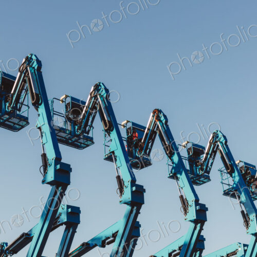 Row of hydraulic mobile cherry picker platforms at outdoor storage facility