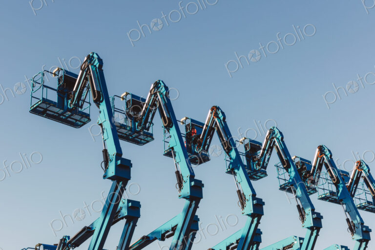 Row of hydraulic mobile cherry picker platforms at outdoor storage facility