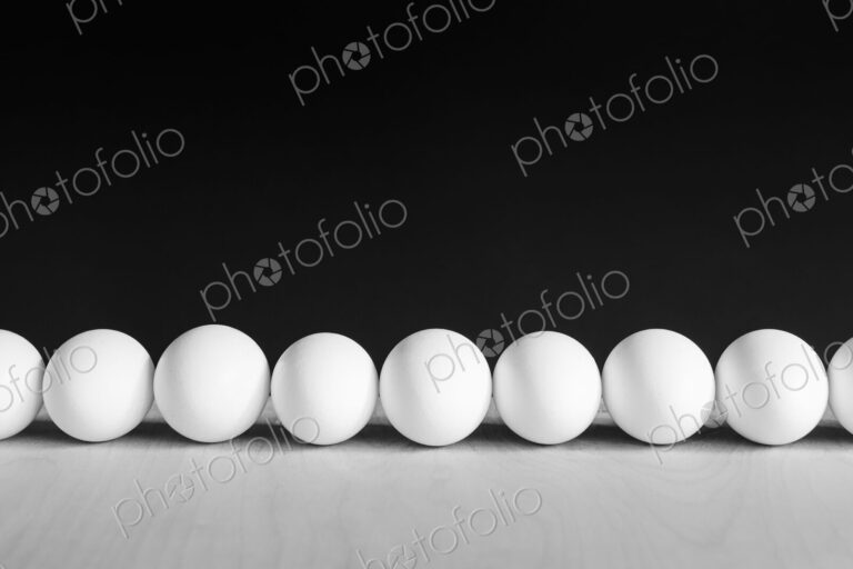 Row of white, free range, organic eggs, black background