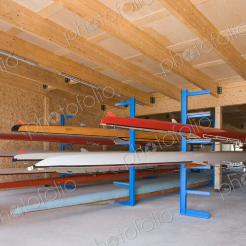 Rowing sculls or boats stored on rack in boathouse.