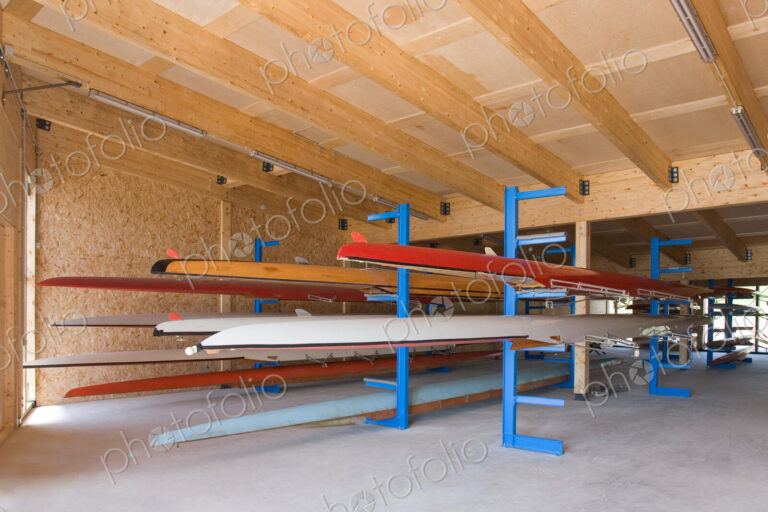 Rowing sculls or boats stored on rack in boathouse.
