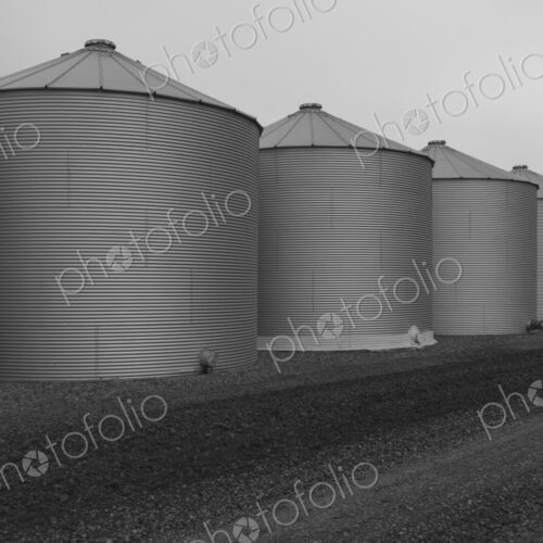 Rows of grain silos, stormy skies in distance, Saskatchewan, Canada.