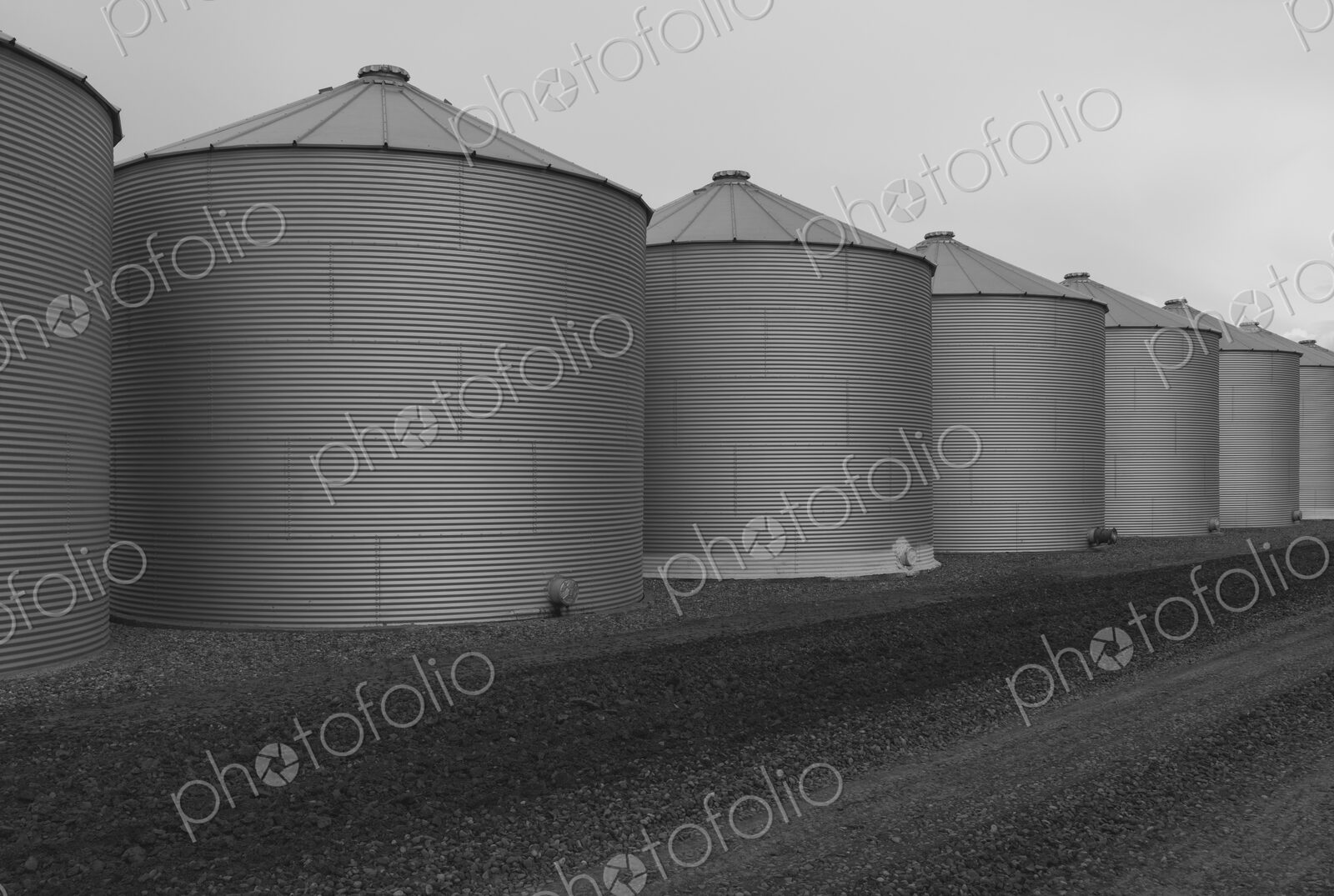 Rows of grain silos, stormy skies in distance, Saskatchewan, Canada.
