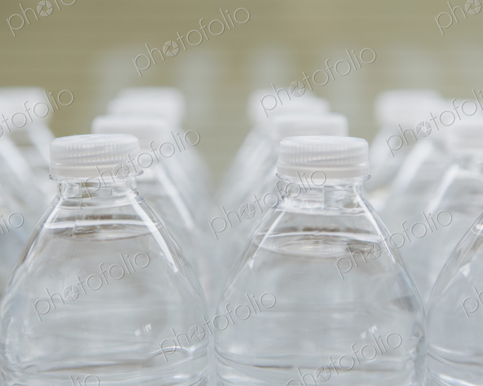 Rows of water-filled plastic bottles with screw caps.