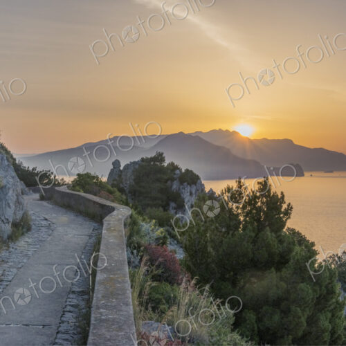 Rural hilltop road with sun rising or setting behind. Rural hilltop road with sun rising or setting behind.