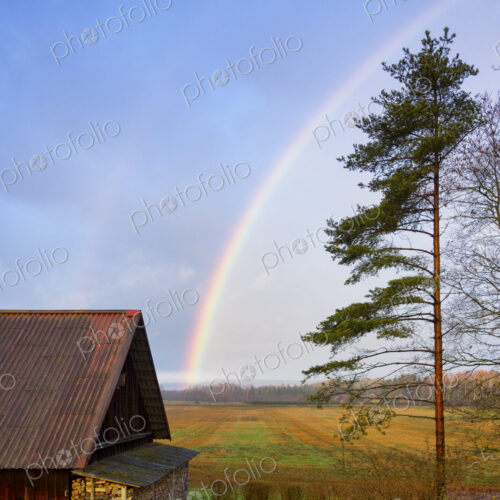 Rural scene, a rainbow in the sky over a barn, after rain. Rural scene, a rainbow in the sky over a barn, after rain.
