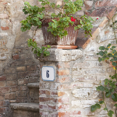 Rustic entryway into a traditional Tuscan home, a flowerpot on the stoop. Rustic entryway into a traditional Tuscan home, a flowerpot on the stoop.