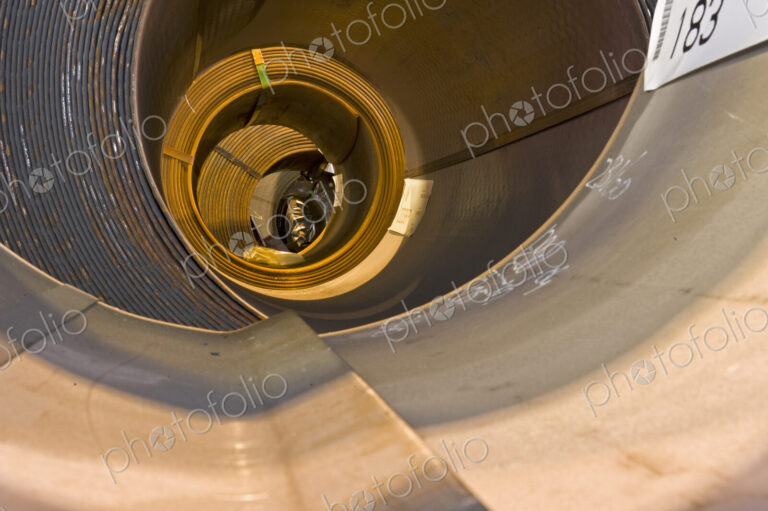 Rusty steel sheets rolled up and waiting to be transported.