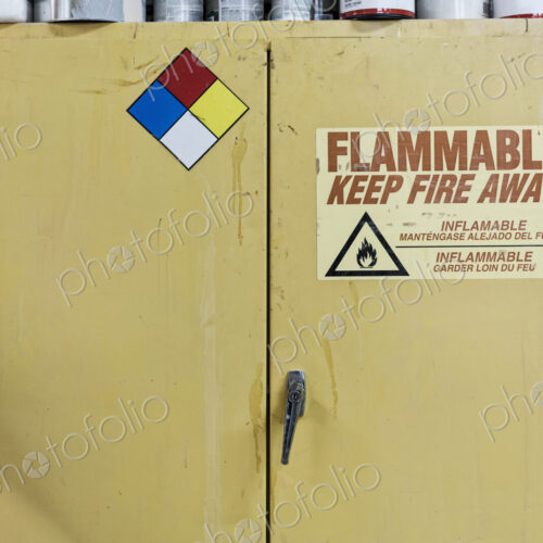 Safety sign reminders mounted to a metal cabinet in a woodworking factory. Safety sign reminders mounted to a metal cabinet in a woodworking factory.