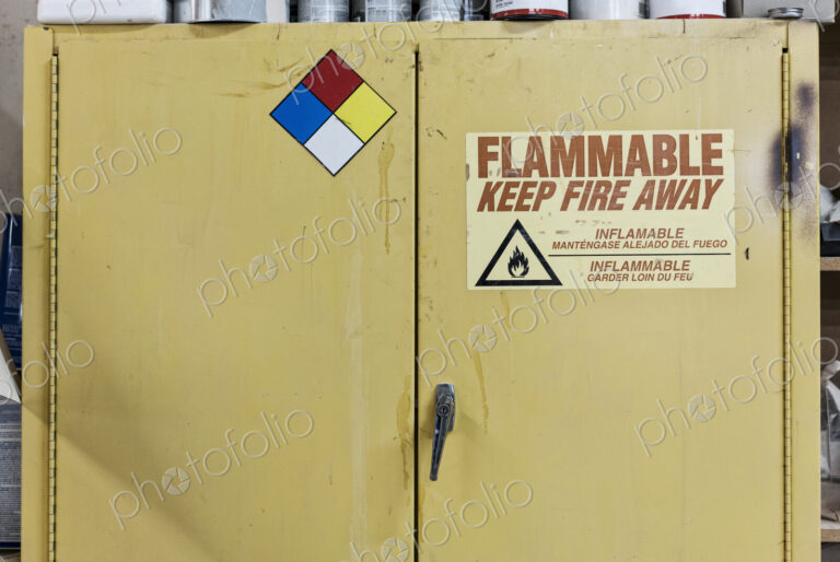 Safety sign reminders mounted to a metal cabinet in a woodworking factory.