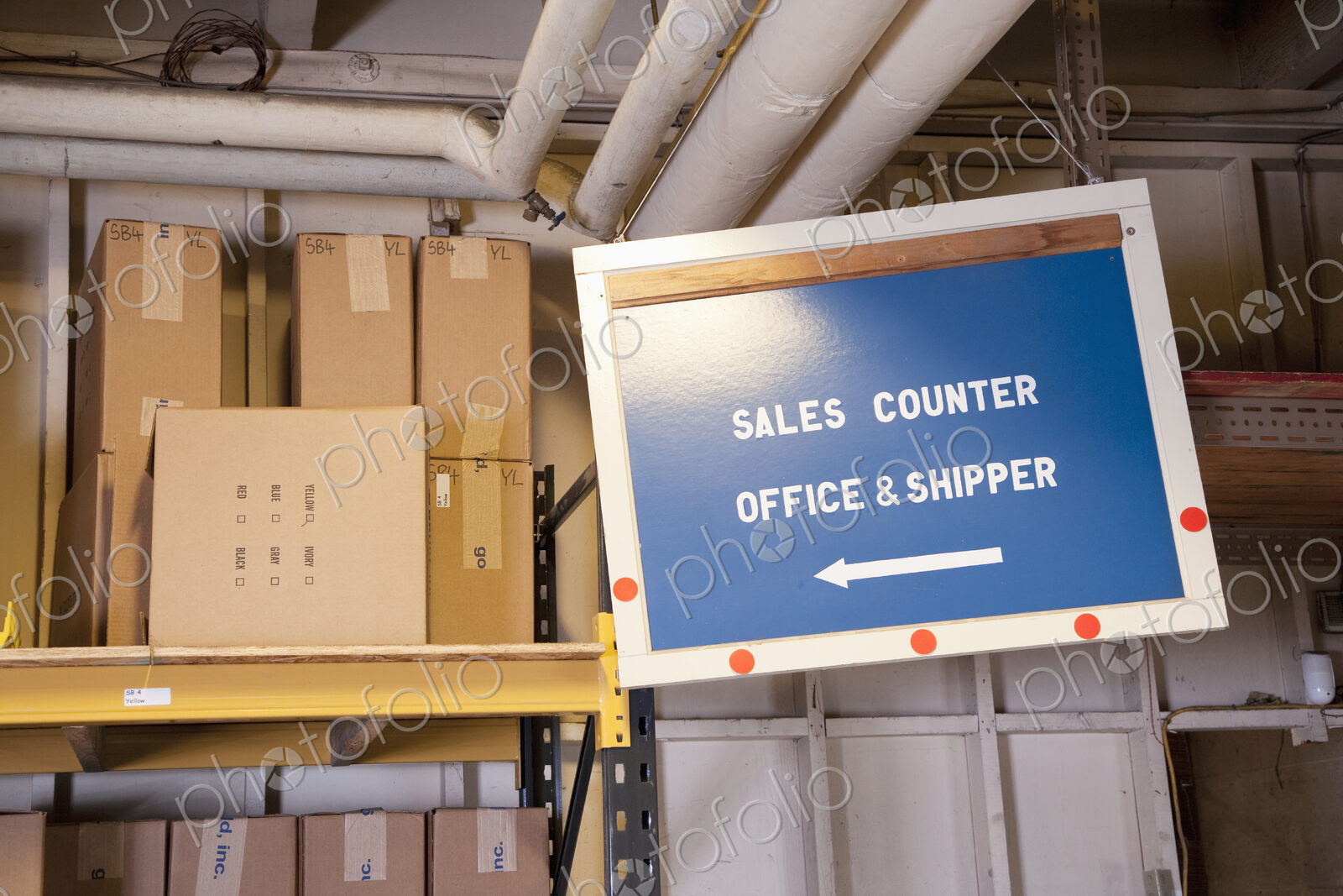 Sales counter sign and cardboard boxes on shelf in warehouse.