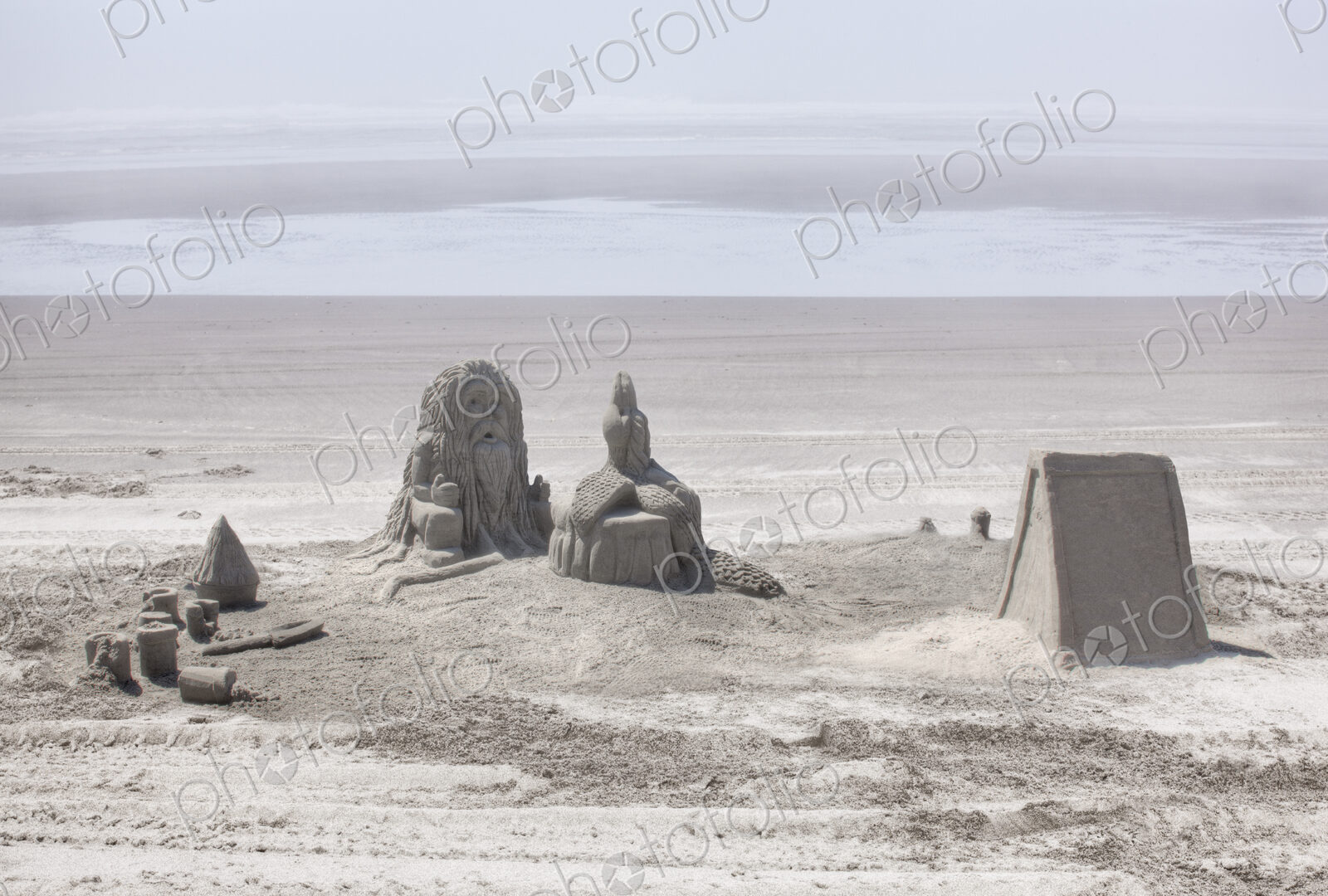 Sand castles referencing Native American culture on sandy beach.