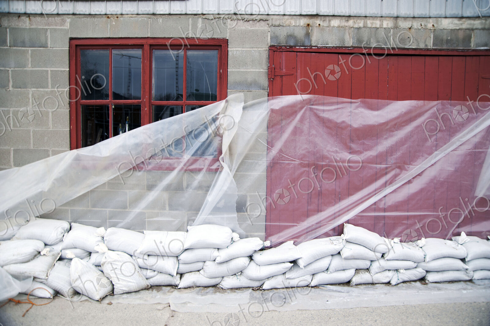 Sandbags and glass sheet on building wall
