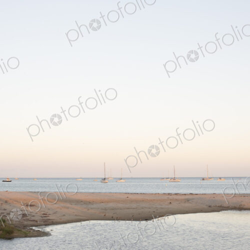 Sandy beach and ocean, sailing boats in the distance. Sandy beach and ocean, sailing boats in the distance.