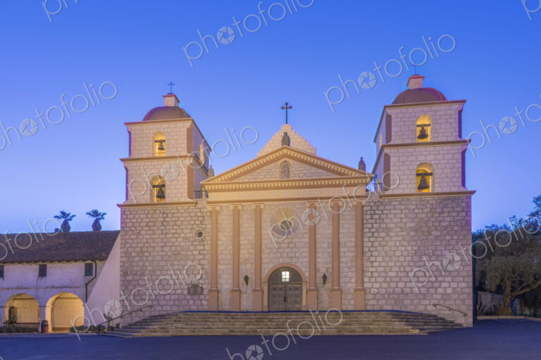 Santa Barbara mission, an 18th century Spanish colonial style church building at dusk,…