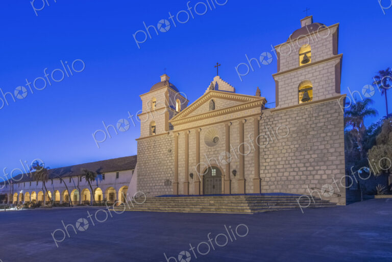 Santa Barbara mission, an 18th century Spanish colonial style church building at dusk,…