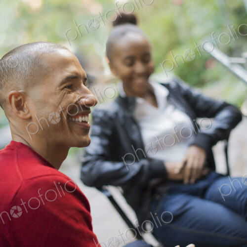 Scenes from urban life in New York City. A man and a teenage girl sitting outdoors.…