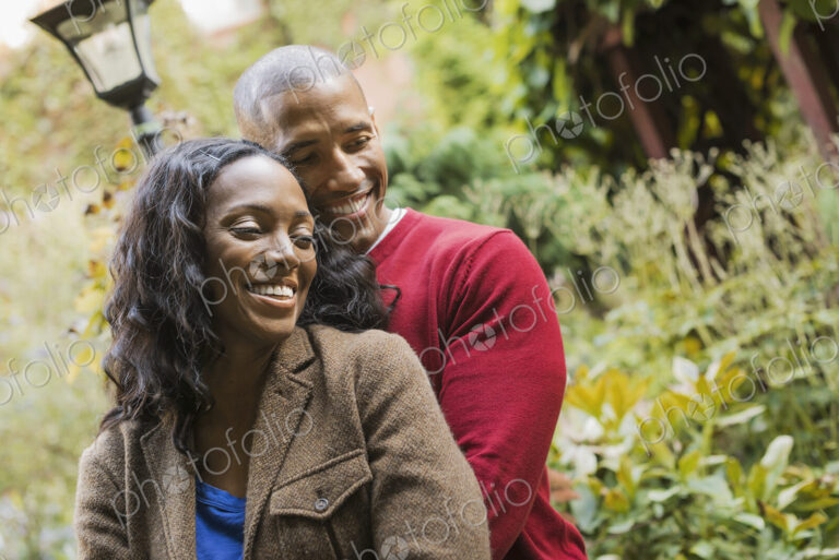 Scenes from urban life in New York City. A man and a woman, hugging each other in an…