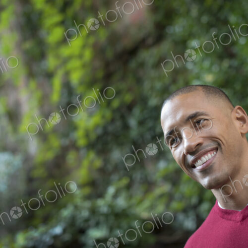 Scenes from urban life in New York City. A man smiling, in a relaxed mood, in a leafy…