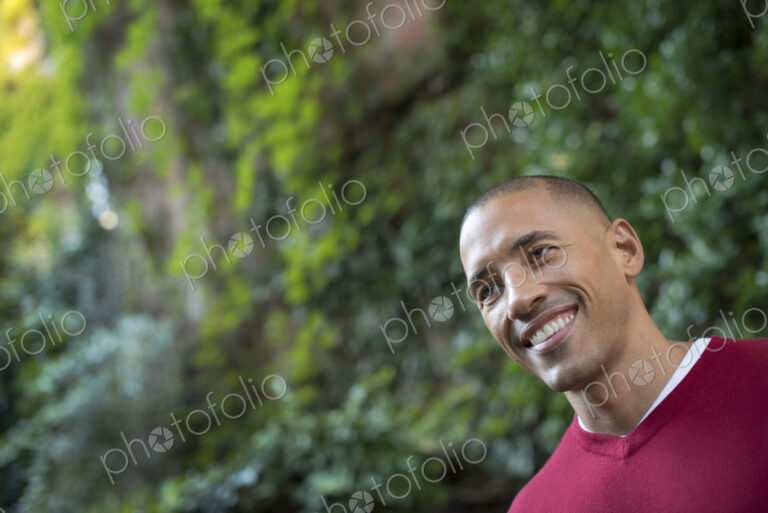 Scenes from urban life in New York City. A man smiling, in a relaxed mood, in a leafy…