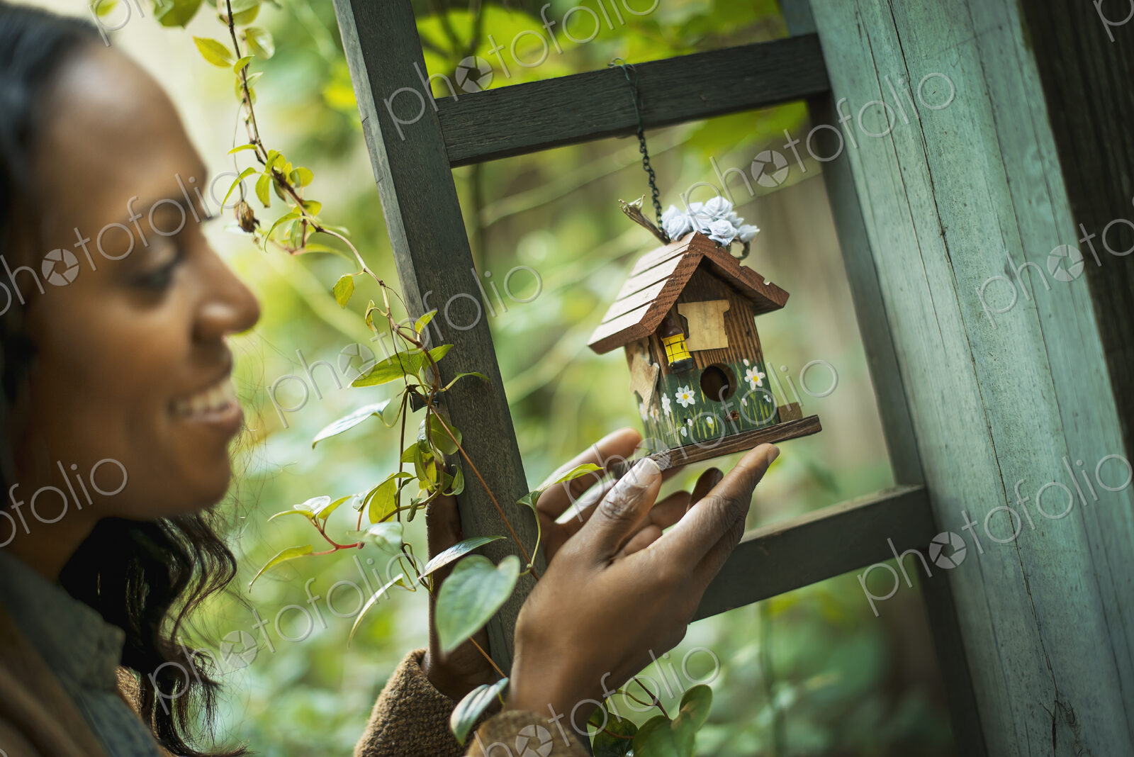 Scenes from urban life in New York City. A woman holding a small painted bird house in…