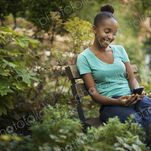Scenes from urban life in New York City. A young teenage girl sitting on a bench,… Scenes from urban life in New York City. A young teenage girl sitting on a bench,…