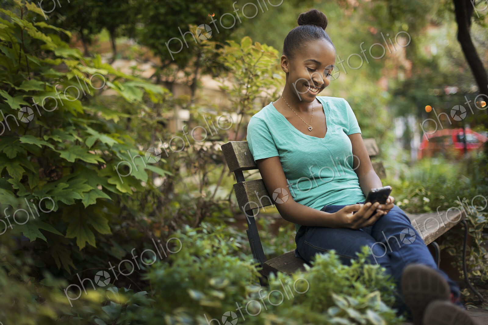 Scenes from urban life in New York City. A young teenage girl sitting on a bench,…
