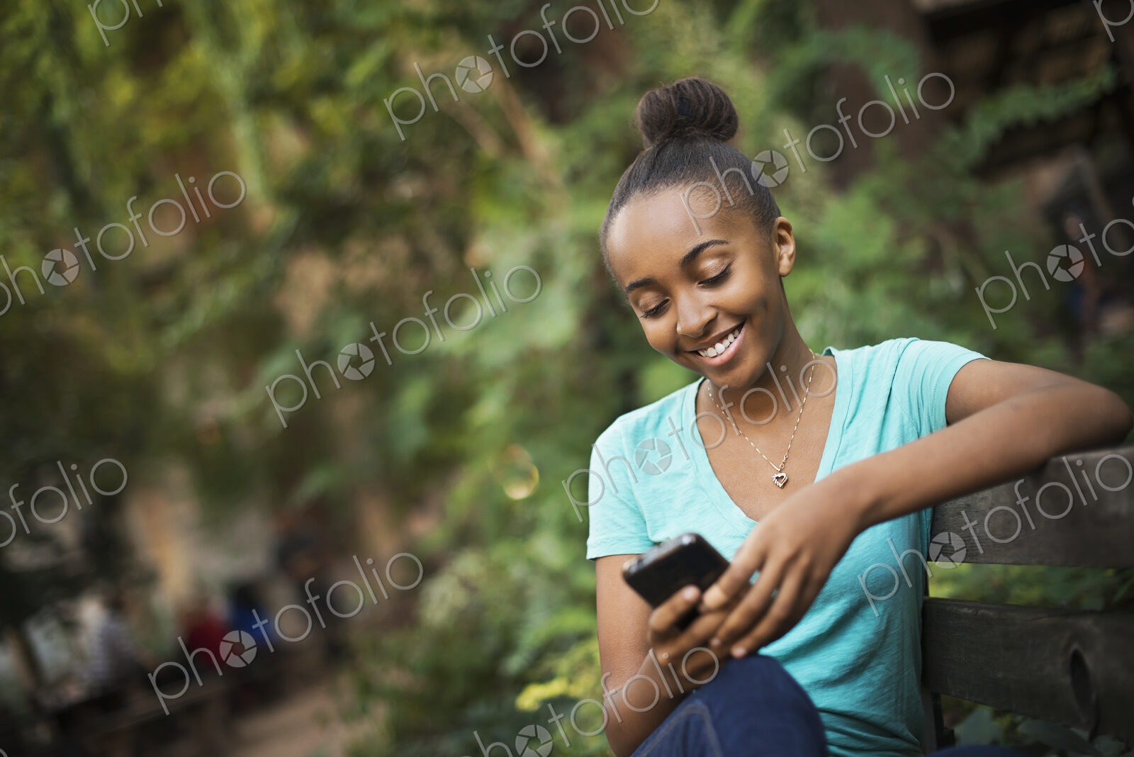Scenes from urban life in New York City. A young teenage girl sitting on a bench,…