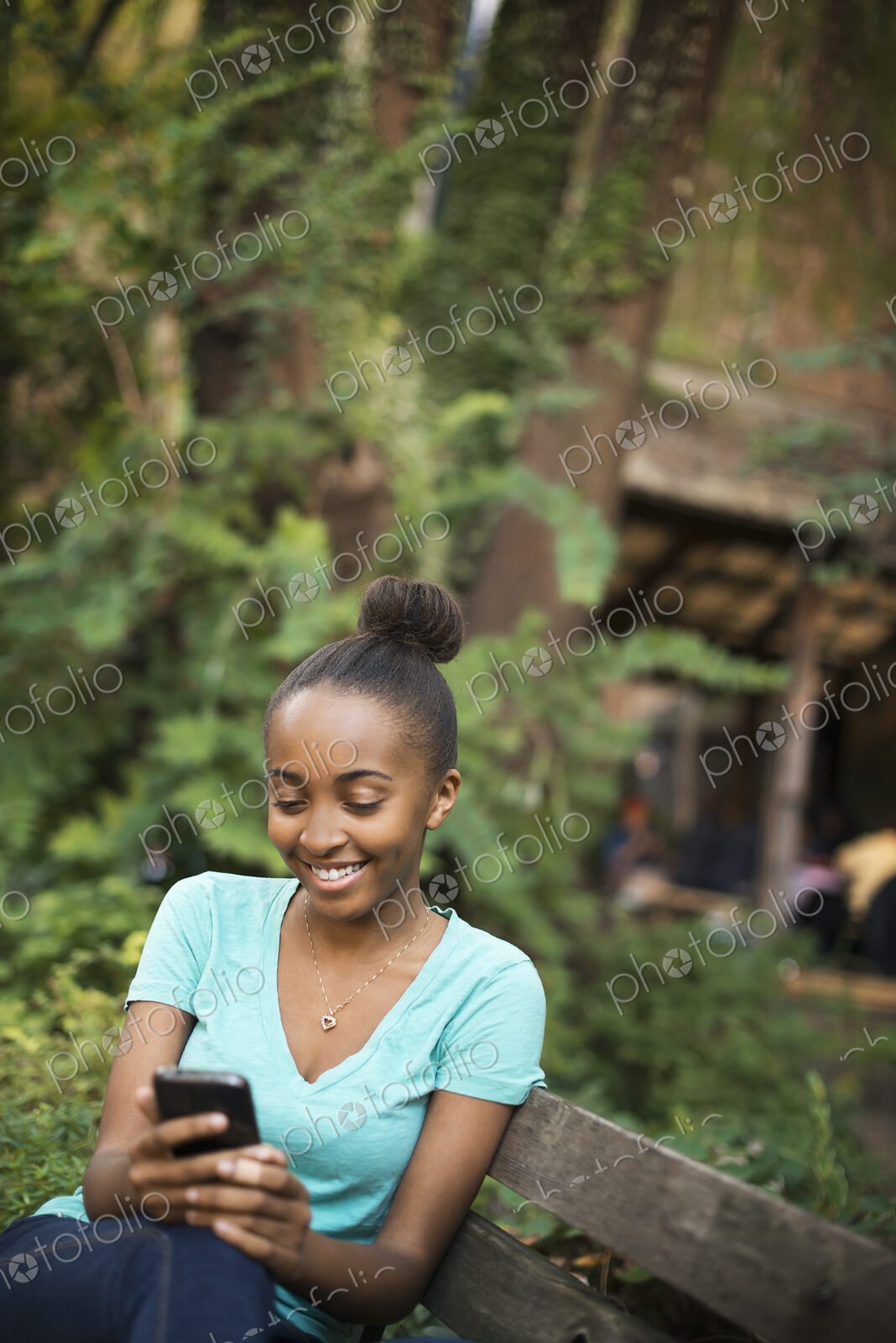 Scenes from urban life in New York City. A young teenage girl sitting on a bench,…