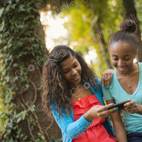 Scenes from urban life in New York City. Two girls looking at a cell phone or computer… Scenes from urban life in New York City. Two girls looking at a cell phone or computer…