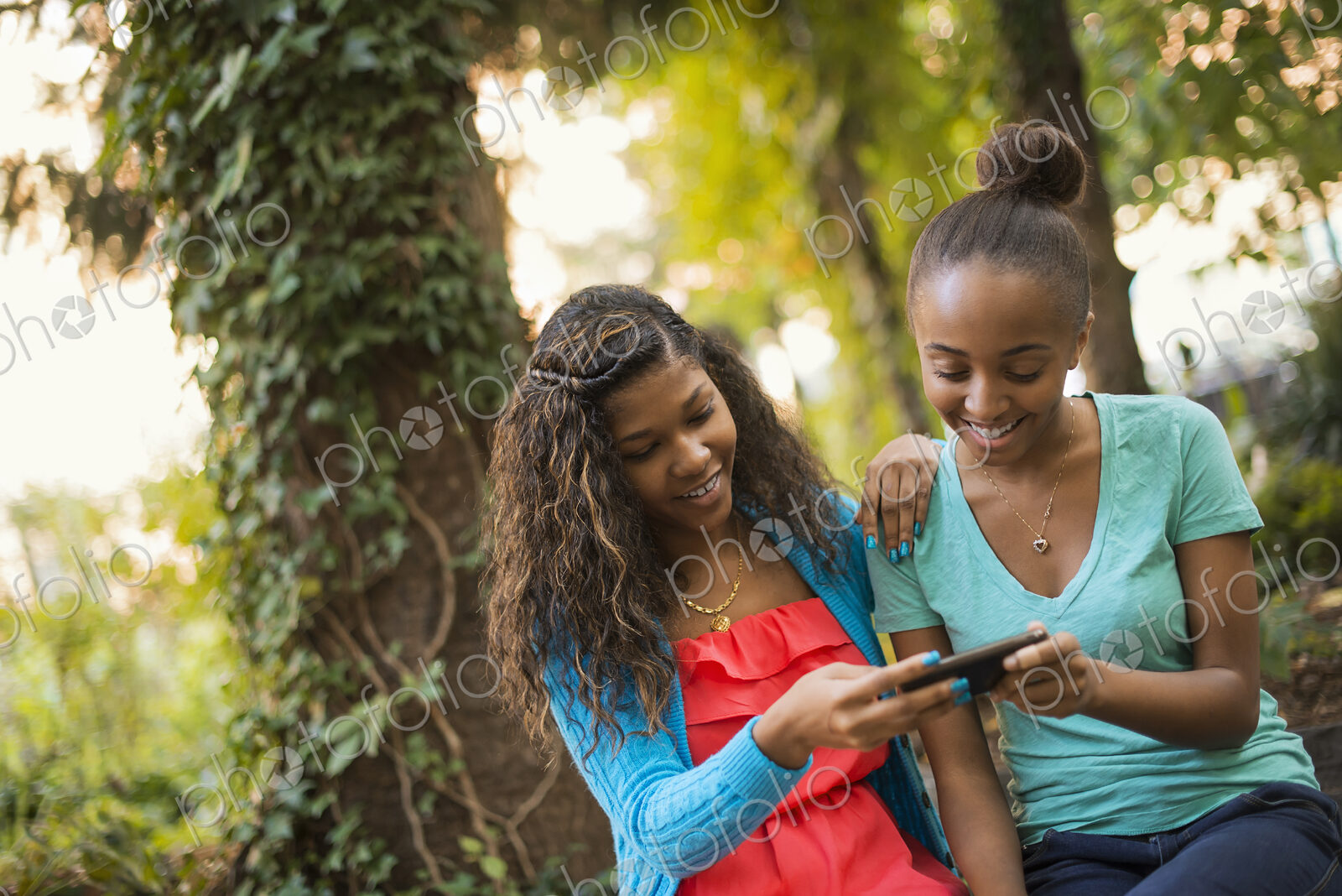 Scenes from urban life in New York City. Two girls looking at a cell phone or computer…